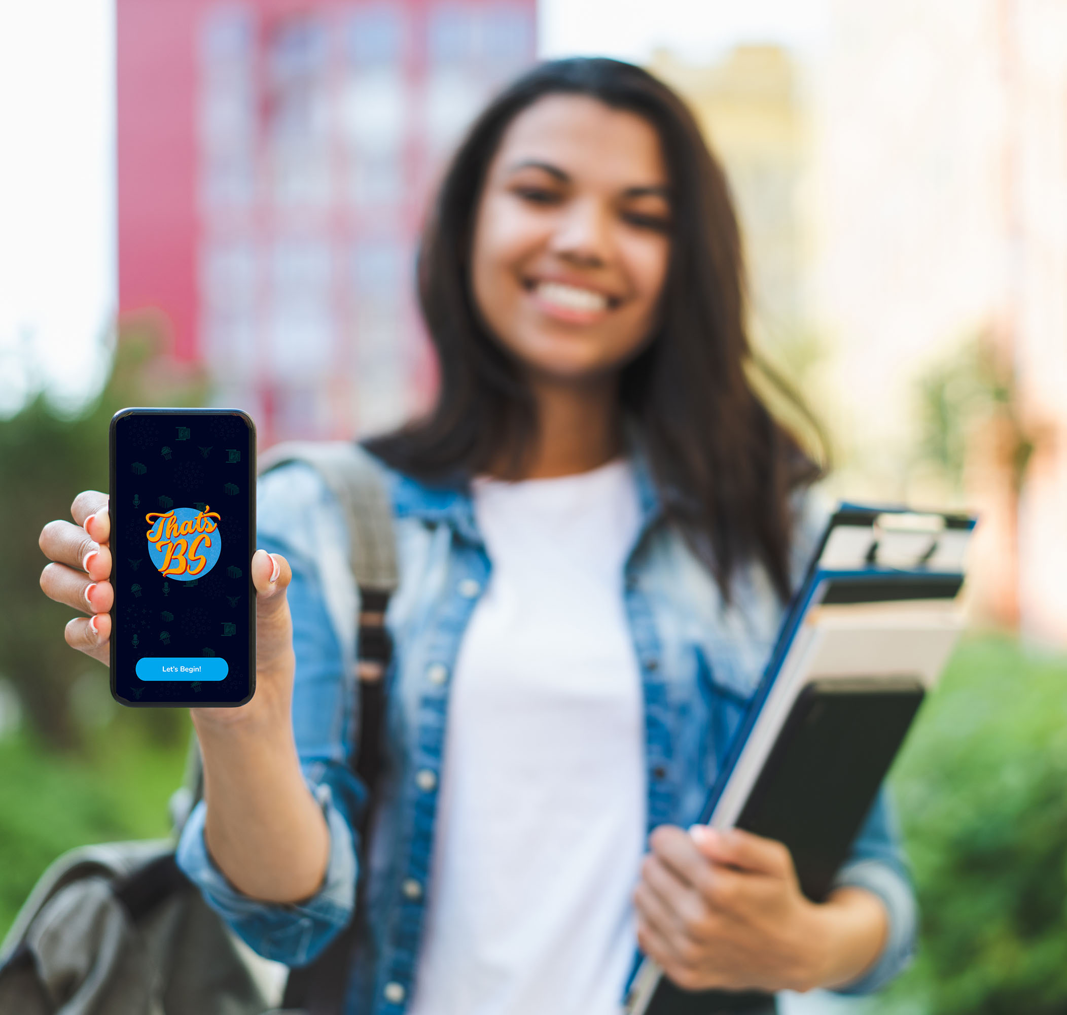 Smiling african american girl student holding smartphone in hand